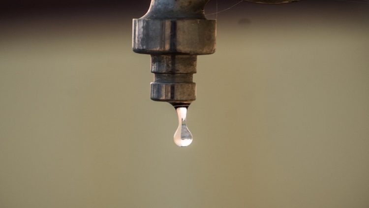 A tap and water droplet .