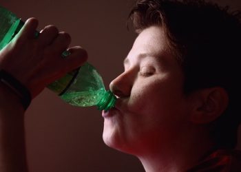 Person consumes a fizzy drink