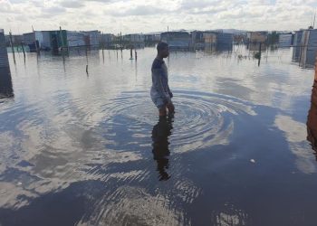 A resident walks in a flooded area.
