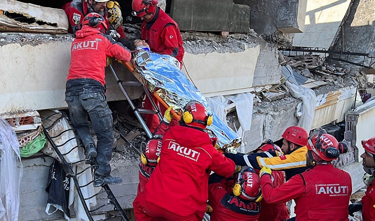 Rescuers carry a woman after she was evacuated from under a collapsed building following an earthquake in Kahramanmaras, Turkey, February 7, 2023.