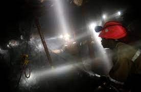 Mine workers inside a shaft drilling and digging.