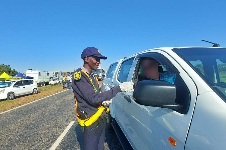 Police officer checking a driver's license during a roadblock