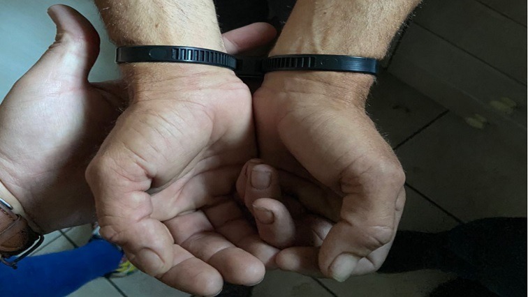 Cuffed hands indicating an arrest