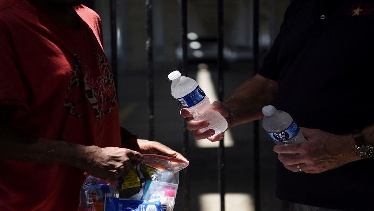A man passes bottled water during heatwave
