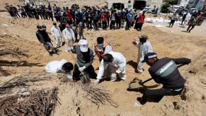 People work to move into a cemetery bodies of Palestinians killed during Israel's military offensive and buried at Nasser hospital.