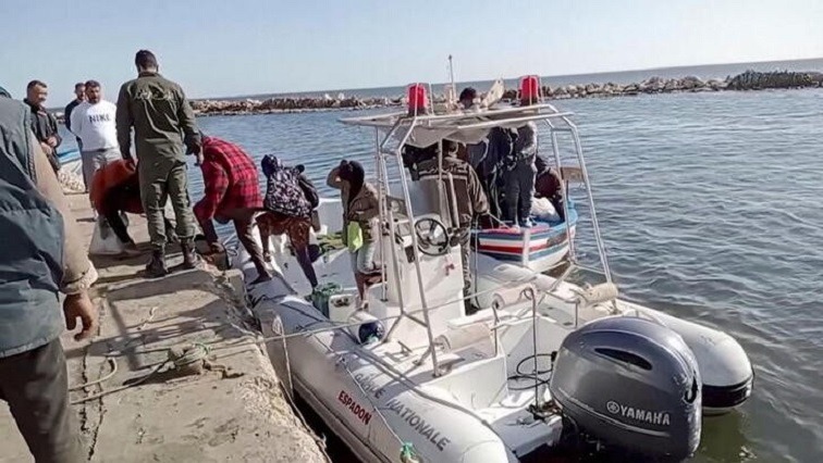 A Tunisian national coast guard helps migrants to get off a rescue boat in Jbeniana, Safx, Tunisia April 23, 2022.